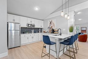 Marietta apartment for rent - a kitchen with white cabinetry and a large white island with three blue chairs