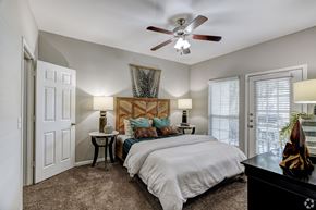 Houston apartment for rent - A bedroom with a large bed and a ceiling fan.