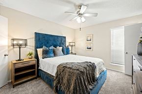 Carrollton apartment for rent - a bedroom with a bed and a ceiling fan at Keller Oaks, Carrollton 