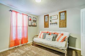 Nashville townhouse for rent - A bedroom with a bed and a window with orange curtains.