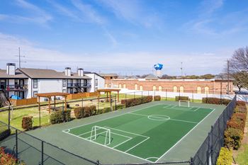 A basketball court with apartments in the background