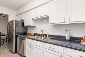 Nashville townhouse for rent - A kitchen with white cabinets and black countertops.