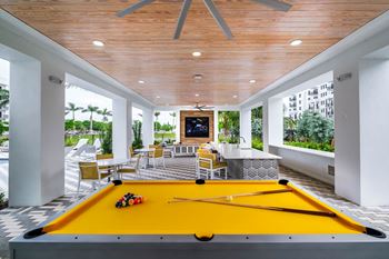 A pool table in a patio area with a fireplace