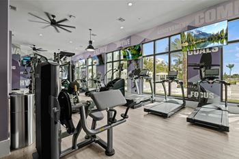 A gym with cardio machines and a view of the beach