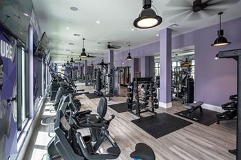 A gym with various machines and chairs in it