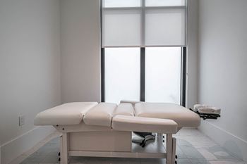 A spa room with two massage tables and two windows
