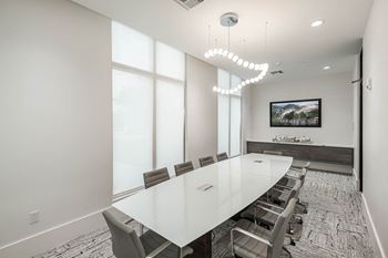 A conference room with a long white table and chairs