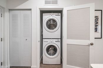 A small laundry room with a washing machine and a dryer