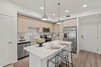 A kitchen with a large island and stainless steel appliances