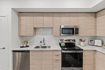 A kitchen with a stove and a sink and a microwave