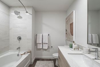 A bathroom with a tub and a sink and a mirror