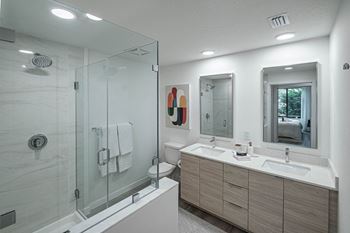 A bathroom with a shower and a sink and a mirror