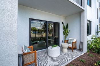 A patio with a toilet and chairs and a zebra rug