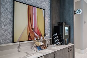 A bathroom with a mirror and a coffee machine on a counter