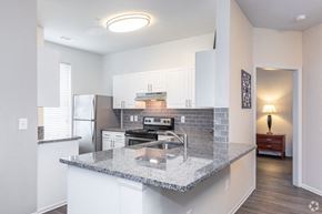 College Park apartment for rent - a kitchen with white cabinets and a granite counter top