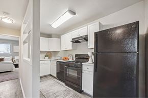 Laurel apartment for rent - a kitchen with black appliances and white cabinets