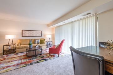 Capitol Heights apartment for rent - A living room with a red chair and a grey desk.