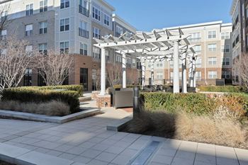 Outdoor green space with ornate landscaping, water features, and led lighting