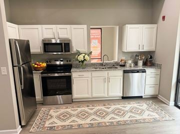 Clarksville apartment for rent - A kitchen with white cabinets and a patterned rug on the floor.