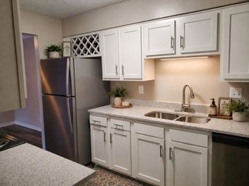 Louisville apartment for rent - A kitchen with white cabinets and a stainless steel refrigerator.