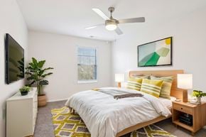 Florissant apartment for rent - A bedroom with a bed, a ceiling fan, and a painting on the wall.