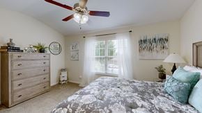 Louisville townhouse for rent - A bedroom with a large bed and a ceiling fan.