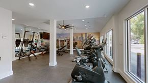 Louisville townhouse for rent - A gym with a row of stationary bikes and a fan.