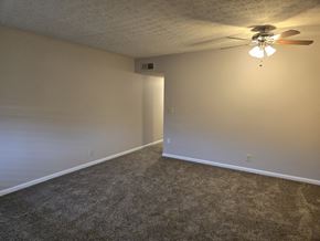 Louisville apartment for rent - A room with a ceiling fan and carpeted floor.
