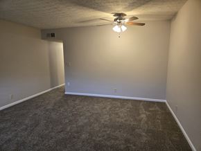 Louisville apartment for rent - A room with a ceiling fan and carpeted floor.