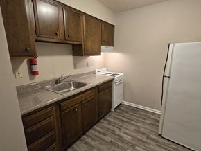 Louisville apartment for rent - A kitchen with a white fridge and wooden cabinets.