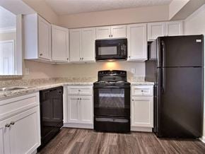 Evansville apartment for rent - a kitchen with black appliances and white cabinets