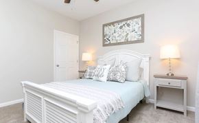 Richmond apartment for rent - A white bedroom with a bed, nightstand, and a painting on the wall.