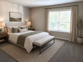 Louisville apartment for rent - A bedroom with a large bed and a window with curtains.