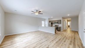 Louisville apartment for rent - A spacious room with a ceiling fan and wooden flooring.