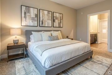Clarksville apartment for rent - A bedroom with a large bed and two framed pictures on the wall.