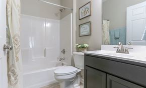 Richmond apartment for rent - A white toilet is in a bathroom with a white door and a white sink.