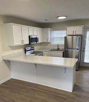 Lagrange apartment for rent - A kitchen with white cabinets and a white island.