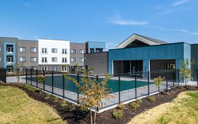 Clarksville apartment for rent - A modern building with a pool in front.