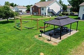 Evansville apartment for rent - a picnic area with hammocks and a gazebo in a grassy yard