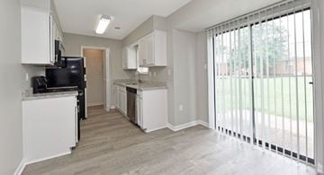 Memphis townhouse for rent - A kitchen with white cabinets and a black refrigerator.