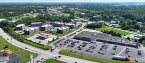 Sellersburg apartment for rent - A large parking lot is surrounded by buildings and a highway.