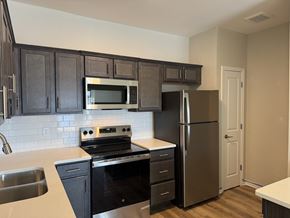 Louisville apartment for rent - A kitchen with dark cabinets and stainless steel appliances.