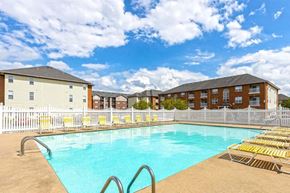 Evansville apartment for rent - a swimming pool in front of a building