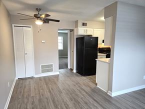 Louisville apartment for rent - A black refrigerator in a kitchen with white walls and wood flooring.