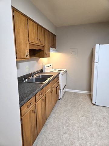 Louisville apartment for rent - A kitchen with wooden cabinets and a white refrigerator.
