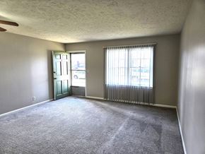 Louisville apartment for rent - A room with a carpeted floor and a window with blinds.