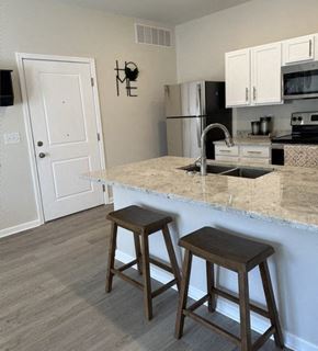 Louisville apartment for rent - a kitchen with a marble counter top and two stools