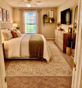 Louisville apartment for rent - A bedroom with a large bed and a window with curtains.