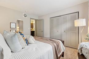 Louisville apartment for rent - A bedroom with a bed, dresser and closet  at Avenue in the Highlands Apartments in Louisville