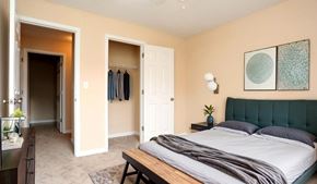 Louisville apartment for rent - A bedroom with a bed, a dresser, and a mirror.